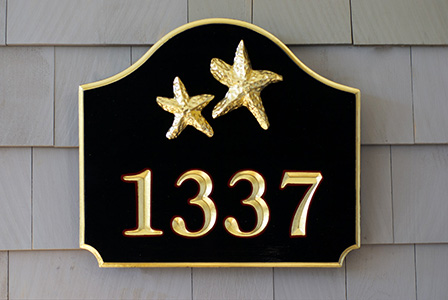 A carved address plaque with two star fish gilded in 23k gold leaf