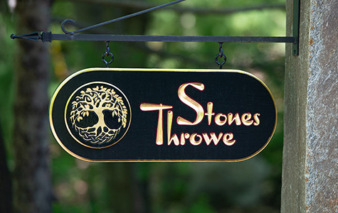 stones throw sign on granite post with iron arm bracket gilded Irish tree of life